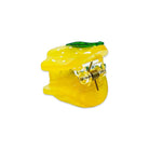 Yellow lemon-shaped object with a green top on a white background