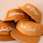 Four orange caps with white text on a beige background