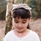 Young girl wearing a headband with a floral pattern outdoors