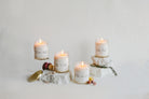 Four candles with labels on a light gray background