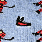 Close-up of a knit fabric with a light blue background and a repeating pattern of hockey players and ice skates in black, red, and white.