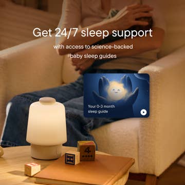Person sitting on a couch with a baby sleep guide app displayed, promoting 24/7 sleep support.