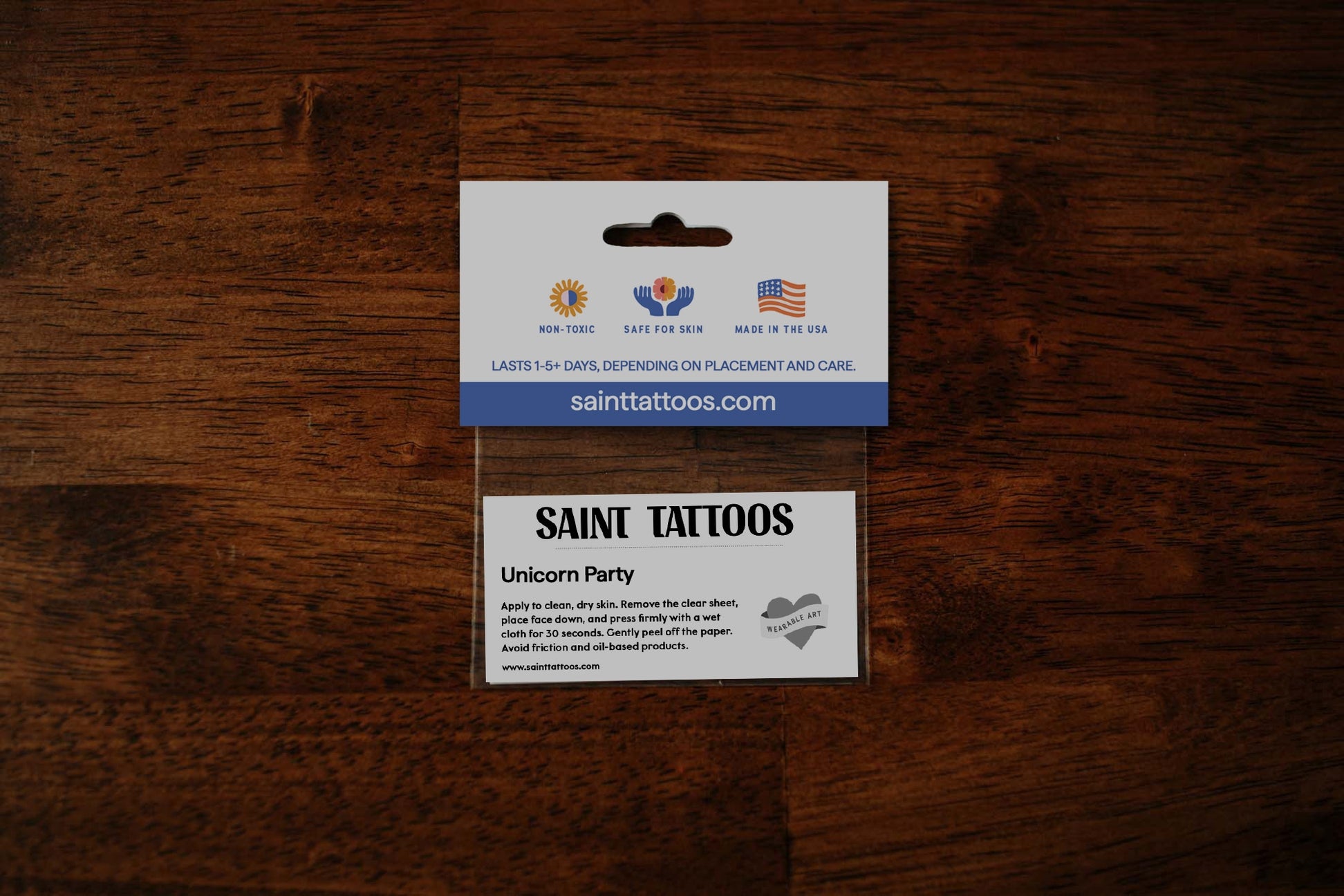Saint Tattoos packaging on a wooden surface