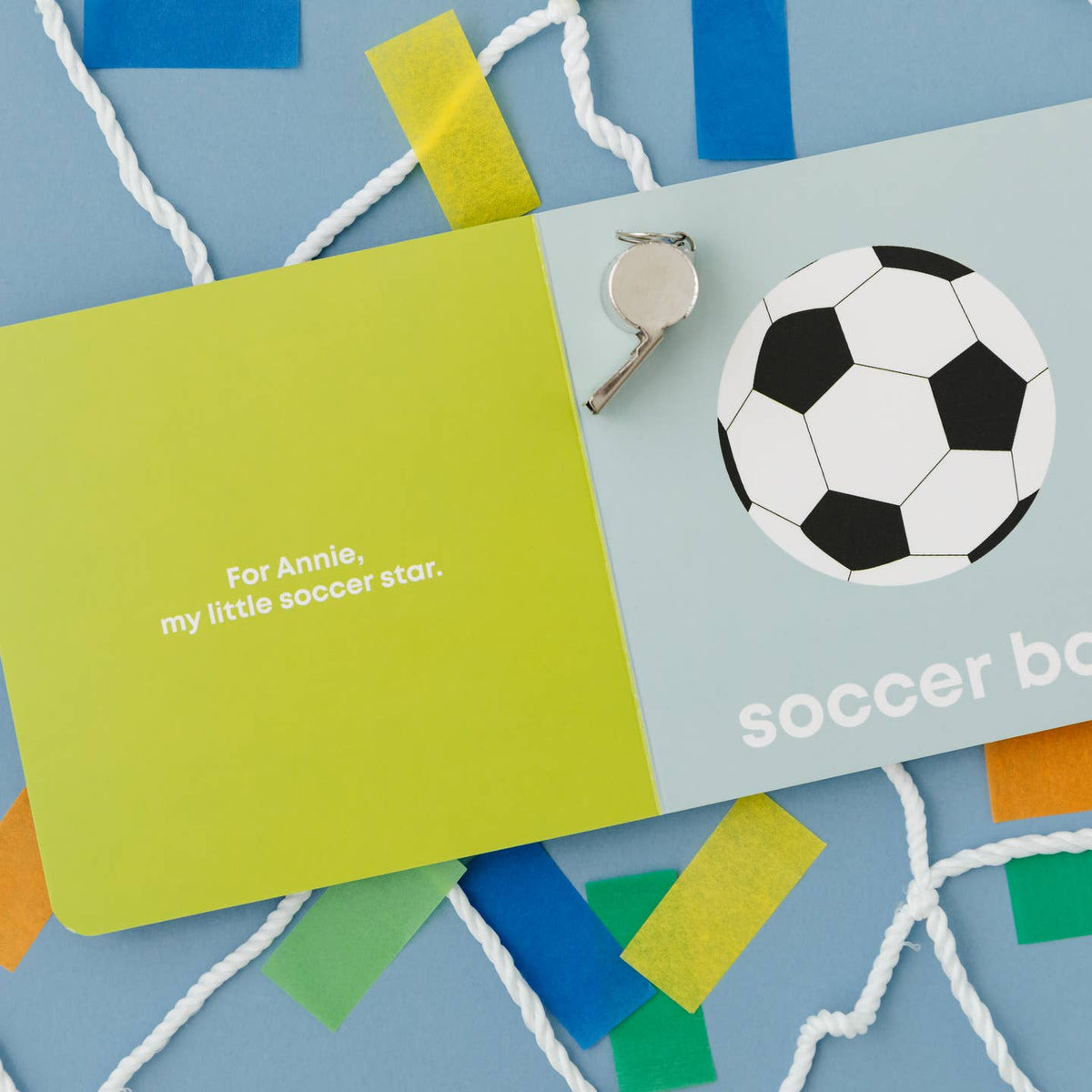 Children's book titled 'soccer boy' with a soccer ball illustration and a green card on a blue background.