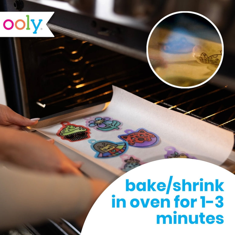 A person's hands are shown sliding a baking sheet with colorful shrinkie charms into an oven. The image includes a circular inset showing a close-up of a shrinkie being heated, a white 'ooly' logo in the top-left corner, and a blue text overlay at the bottom right that reads 'bake/shrink in oven for 1-3 minutes'.