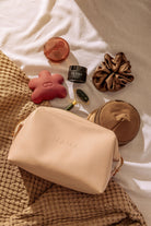 Cosmetic bag with skincare products on a textured surface