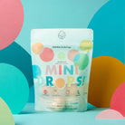 Package of 'Mini Drops' bath bombs with colorful design on a multicolored background