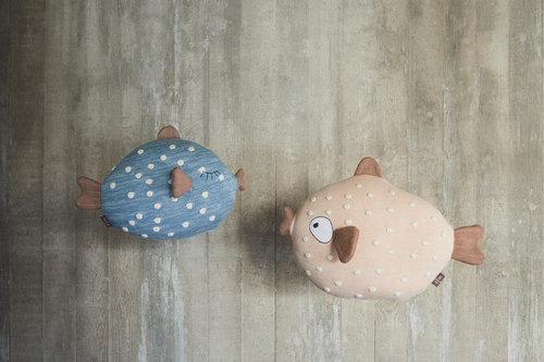 Two plush toys shaped like fish on a textured surface