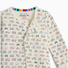 A baby long-sleeve sleep sack with an all-over vehicle print on a cream background. The print features various colorful drawings of cars, buses, planes, and boats.