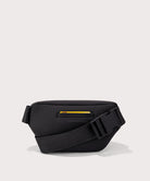 Black waist bag with a yellow zipper on a light gray background