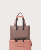 Stack of two bags, one brown and one pink, on a light gray background