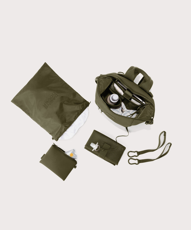 Collection of green travel bags and accessories on a light gray background