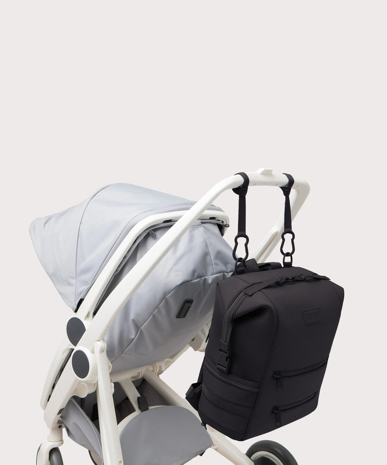 Navy blue backpack attached to a stroller on a light gray background