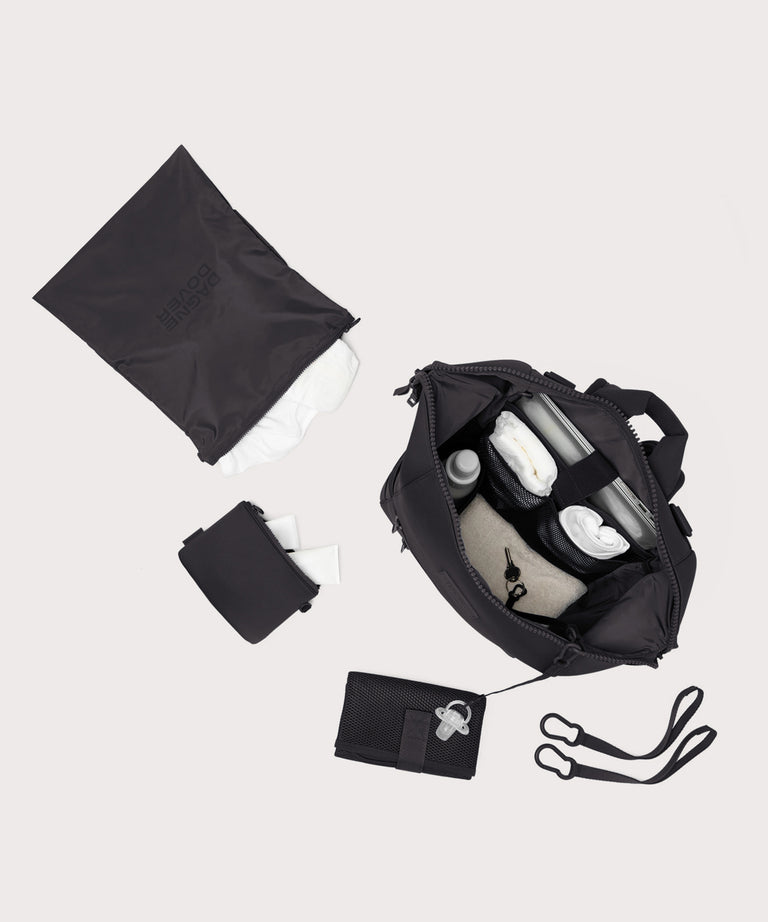 Navy blue travel bag with accessories on a light gray background