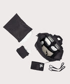 Navy blue travel bag with accessories on a light gray background