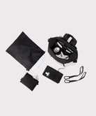 Black travel bag with accessories on a light gray background