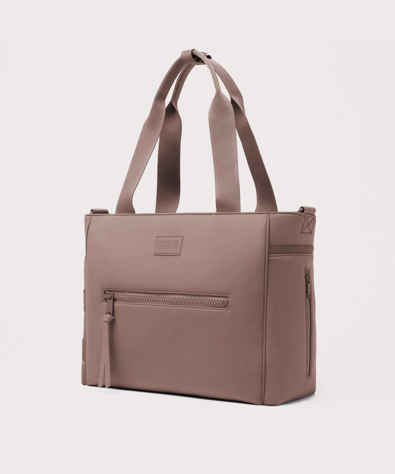 Brown tote bag with a visible brand label on a light gray background