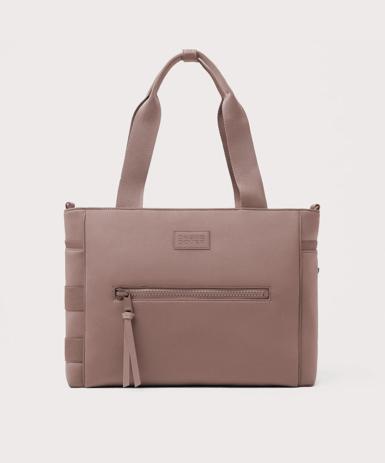 Brown tote bag with a visible brand label on a light gray background