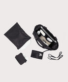 Collection of black travel accessories including a bag, wallet, and pouch on a light gray background