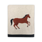 Knitted blanket with a horse design on a white background