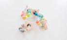 Colorful baby teething ring with star-shaped wooden elements on a white background