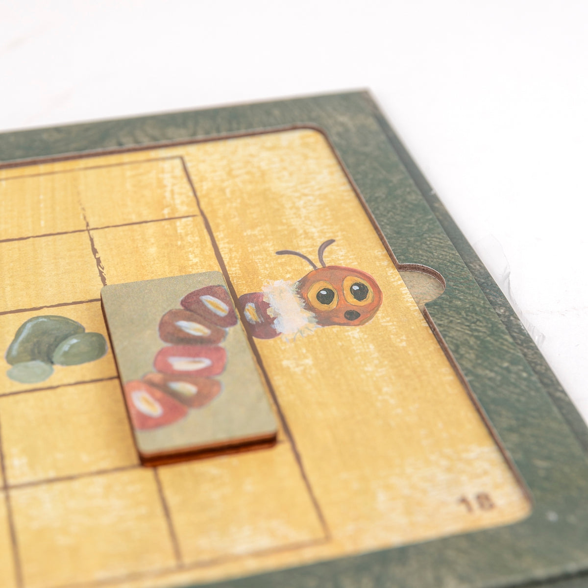 Wooden toy with a caterpillar design on a checkered surface