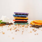 Stack of colorful chocolate bars with various ingredients on a white background