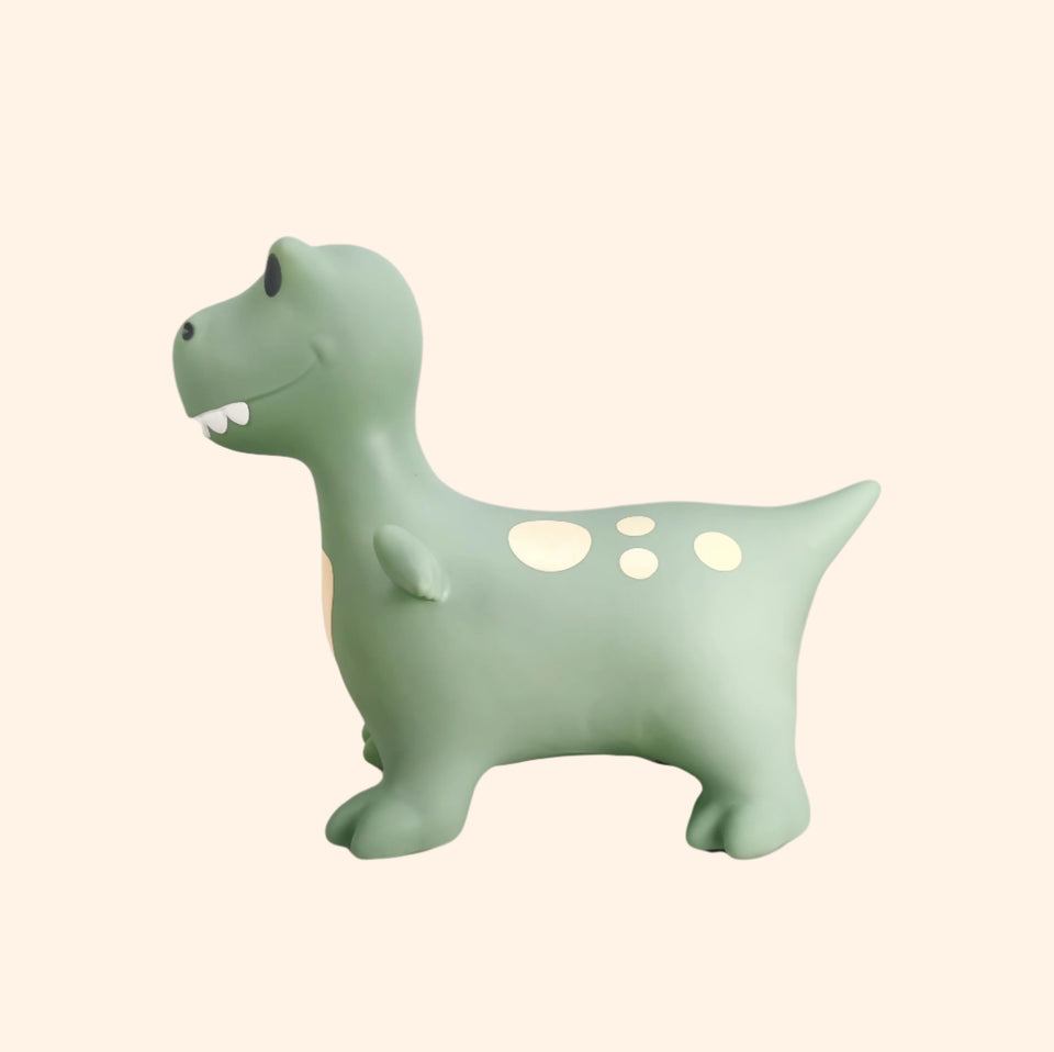 Green dinosaur-shaped night light on a beige background