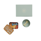 Pet toy set with a small bowl, treat container, and bone-shaped toys on a white background.