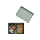 Green box with a toy and treat container on a white background