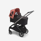 Black stroller with red canopy on a white background