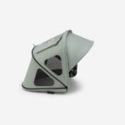 A sage green stroller canopy with mesh windows and black trim, shown from an elevated side angle on a clean white background.