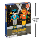 A boxed toy product labeled Superheroes Magnetic Costume Builder by Petit Collage, shown at a slight angle on a plain white background, featuring illustrated superhero characters against a dark city skyline at night with dimension markings.