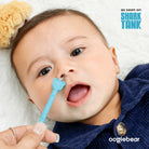 Baby with a blue toothbrush featuring a bear design, with 'Shark Tank' and 'oogiebear' branding.