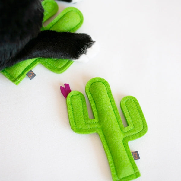 Green cactus-shaped cat toy with a purple flower on a white background