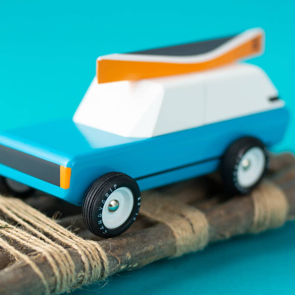 Toy car with a blue body and white roof on a blue background