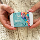 Cotton Tales BFF Friendship Bracelet Kit held by hands on a knitted fabric background