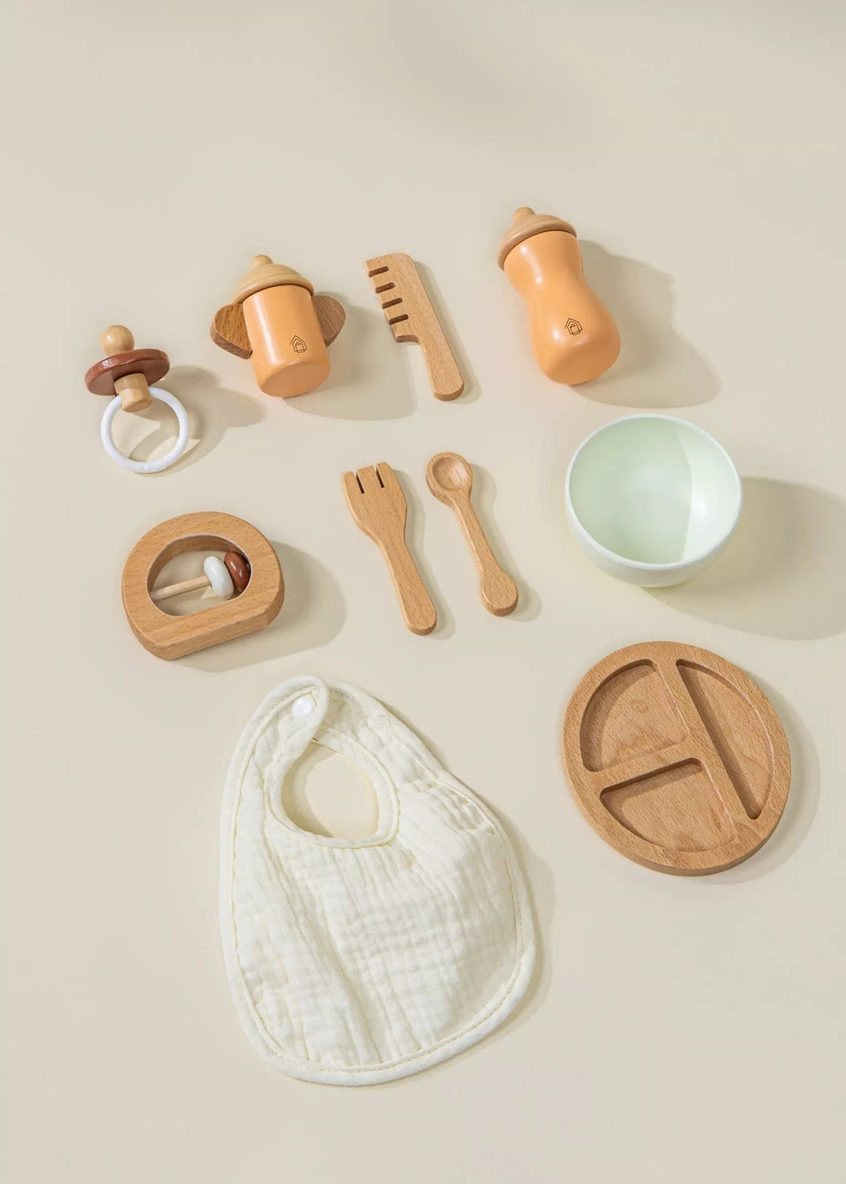 Collection of wooden baby toys and utensils on a beige background