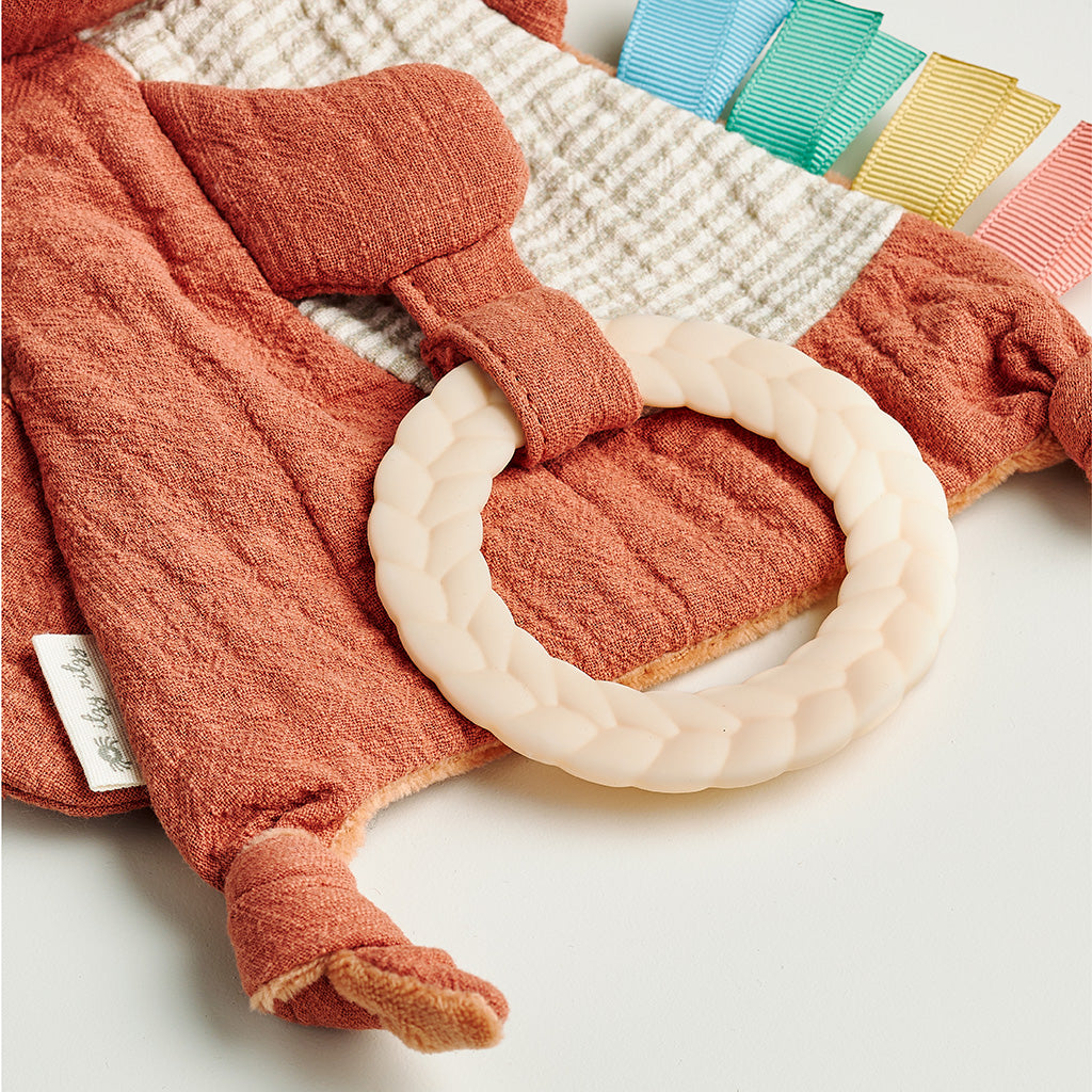 Textured red baby garment with a white ring on a textured surface
