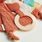 Textured red baby garment with a white ring on a textured surface