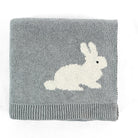 A folded gray knit blanket featuring a white knitted rabbit motif and a ribbed hem, shown on a plain white background.