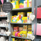 Shelves with various colorful products in a store setting, including greeting cards and decorative items.