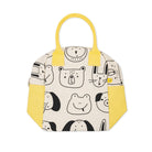 A structured tote bag with a cream-colored canvas body featuring a black line art cartoon animal pattern, bright yellow handles and side panels, and a small yellow zipper pull accent.