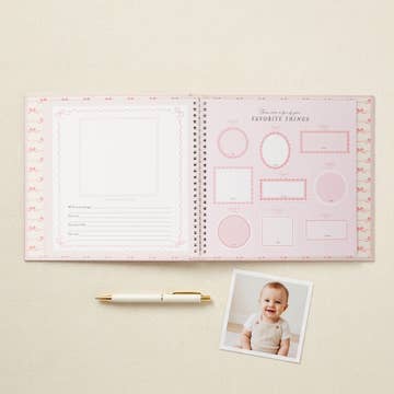 Open planner with decorative elements and a pen on a beige surface