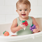 Baby playing with bath toys in a bathtub
