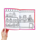 Coloring book page with cute kitchen and cake illustrations held open by a hand.