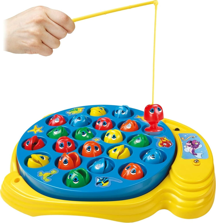A hand holding a fishing rod over a yellow Let's Go Fishin' game board filled with colorful toy fish.