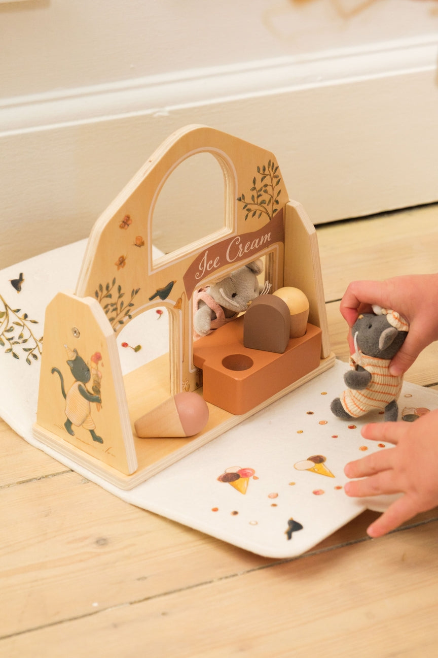 Wooden toy set with ice cream truck and mouse figures on a wooden floor.
