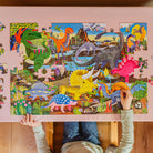 Child playing with a dinosaur puzzle on a pink background