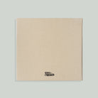Beige fabric panel with a brand logo on a light gray background